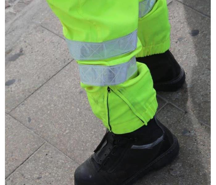 Someone wearing fluorescent green pants and black boots